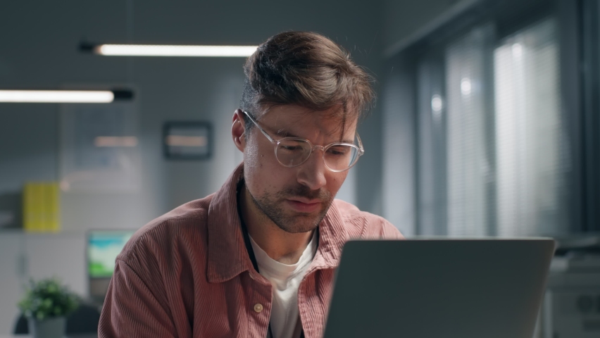 Exhausted businessman working on laptop late in office. Close up portrait of tired overworked entrepreneur at workplace. | Shutterstock HD Video #1086547301