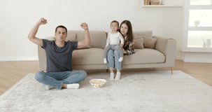 Young family with child on sofa watching tv