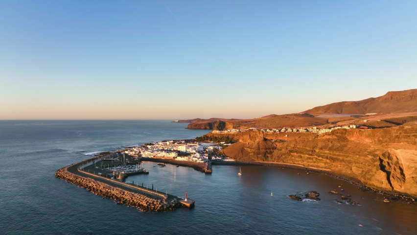 Top view of Puerto de las Nieves town on Gran Canaria island. Aerial view of the harbor on the Canary Islands. Rocky island Gran Canaria in winter. Calm surface of Atlantic ocea