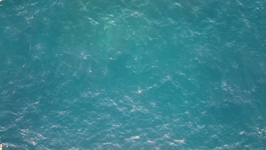Top view of calm water surface. Aerial view of the sea waters. Ocean surface without waves in the daylight. Water outdoors concept. Water texture.