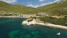 Aerial drone video of beautiful sandy bay and picturesque small chapel of Agios Fokas in island of Skyros, Sporades, Greece