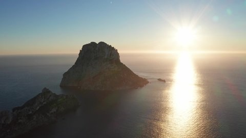 Aerial view of sunset behind Es Vedra Ibiza. Showing ocean and clear skies.
