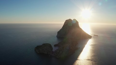 Aerial view of sunset behind Es Vedra Ibiza. Showing ocean and clear skies. Cameraing to right