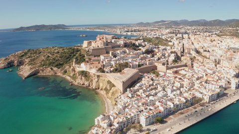 Aerial view of Ibiza city, the Old Town and the city walls of Eivissa with an ocean foreground, filmed by drone, Dolly inement, on a sunny and clear day.