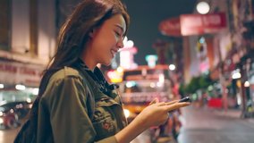 Asian attractive woman backpacker chatting on phone while walk in city. Beautiful woman tourist traveler travel alone on street using smartphone enjoy spend time on holiday vacation trip at night road - Powered by Shutterstock - Get 15% off with code: PIKWIZARD15