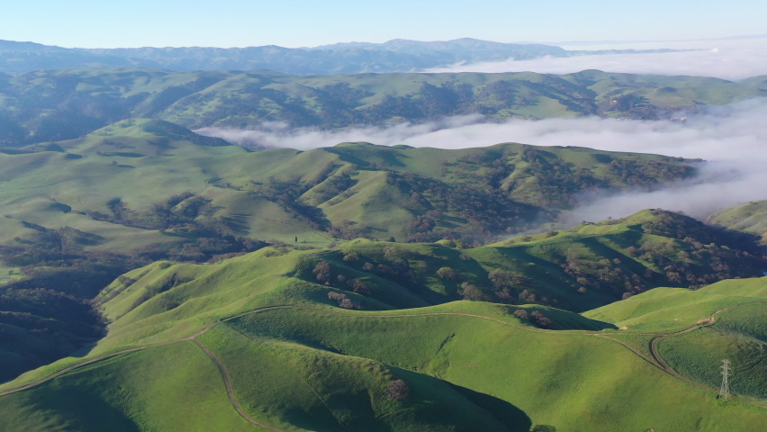 Fog seeps into the rolling hills and valleys of the Tri-valley area of Northern California, just east of San Francisco Bay. This scenic region is known for its many vineyards and open space. Royalty-Free Stock Footage #1086568226