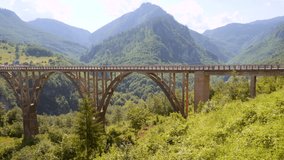 Scenic footage of the arch bridge Durdevica over Tara canyon. Location place national park Durmitor, Montenegro, Balkans, Europe. Cinematic shot. Filmed in UHD 4k video. Discover the beauty of earth.