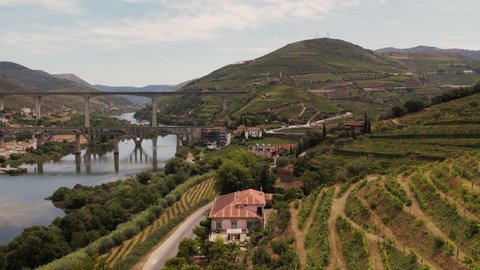 Aerial view over vineyards in Peso da Regua town, Vila Real, Portugal. Drone flying along road to Bridges between hills in wine region