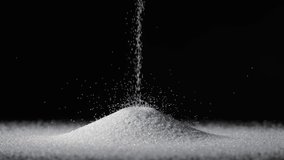 Particles of white dry sand are pouring down forming hill on an isolated black background. Close up shot of crumbling natural sand grains, sandy dune. Heap of petrified natural mineral. - Powered by Shutterstock - Get 15% off with code: PIKWIZARD15
