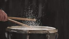 Drummer Hit to drum filled with water. Water splashing and explosion on musical drum instrument  in slow motion.