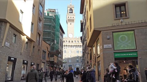 Florence, Italy. January 2022. tourists strolling in the streets of the city center with the view of the Palazzo Vecchio in the background