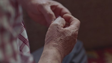Close-up view of the hands of a Muslim old man holding a rosary. Muslim old man praying with a rosary in his hand.