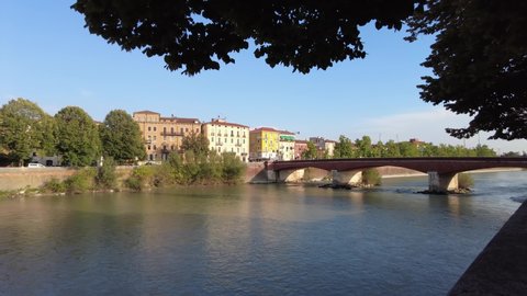 Panorama of the Adige river that crosses the city of Verona at the bridge called "Ponte delle Navi" on a sunny day.