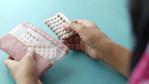 women hand holding birth control pills 