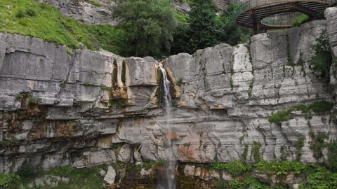 The Kinchkha waterfall in the canyon of the river Okatse. Rest in Georgia. High waterfall in the Imereti region. Rocky ledges of the mountain with green trees. 