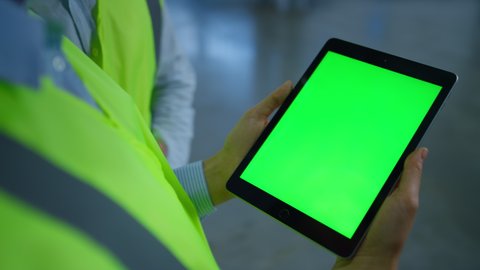 Unknown manufacture workers holding greenscreen tablet collect production data. Supervisor hands analyzing factory information on green screen technological device close up. Digital workplace concept