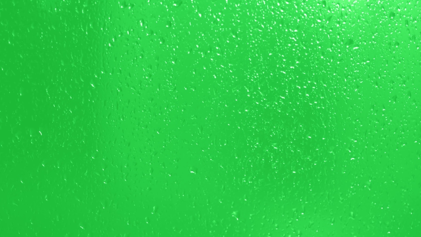 Rain Drops Falling down on green background. Drops trickling down on green glass background. Close up drops on glass or bottle. Royalty-Free Stock Footage #1086626423