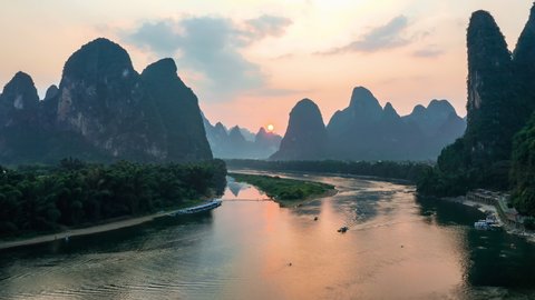 Aerial footage of beautiful mountain and river natural scenery in Guilin at sunrise, China. Lijiang River Scenic Area is a famous tourist attraction in Guilin.