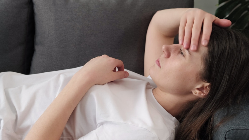 Side view close up of anxious young woman lying on pillow, feeling doubtful making difficult decision. Nervous unhappy brunette girl suffering from negative thoughts, relationship problems concept | Shutterstock HD Video #1086633335