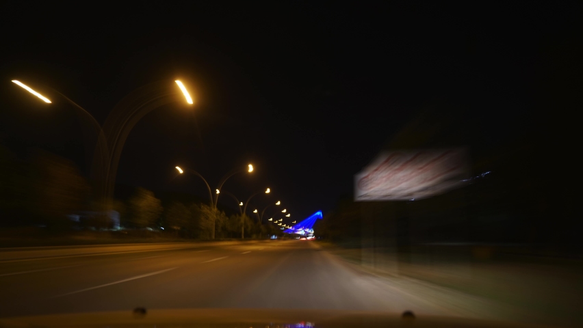 8K 7680x4320 4320p.Night lights and traffic on the city roads.Slow shutter from inside cockpit.Car is moving in dark at night.Vehicles headlights.Bokeh effect and city lights.High fast speed road.