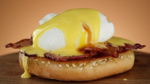 Cutting egg Benedict with runny egg yolk over toast . Healthy breakfast or lunch food. 4K UHD video