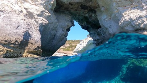Underwater split video of caves in Kleftiko, a beautiful scenic white volcanic rock formation bay with turquoise crystal clear sea often called as the sea Meteora of Greece, Milos island