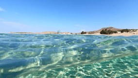 Underwater split video of paradise beach of Simos in island of Elafonisos, Lakonia, Greece