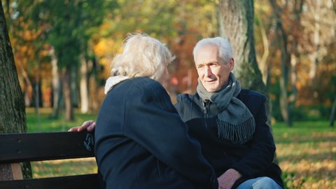 Husband looking at younger woman passing by in park, wife disappointed
