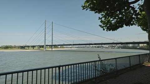 DUSSELDORF, GERMANY - 1 July 2021: Rhein bridge river landscape with calm water. View from the bridge. Sunny summer day. Dusseldorf, Germany