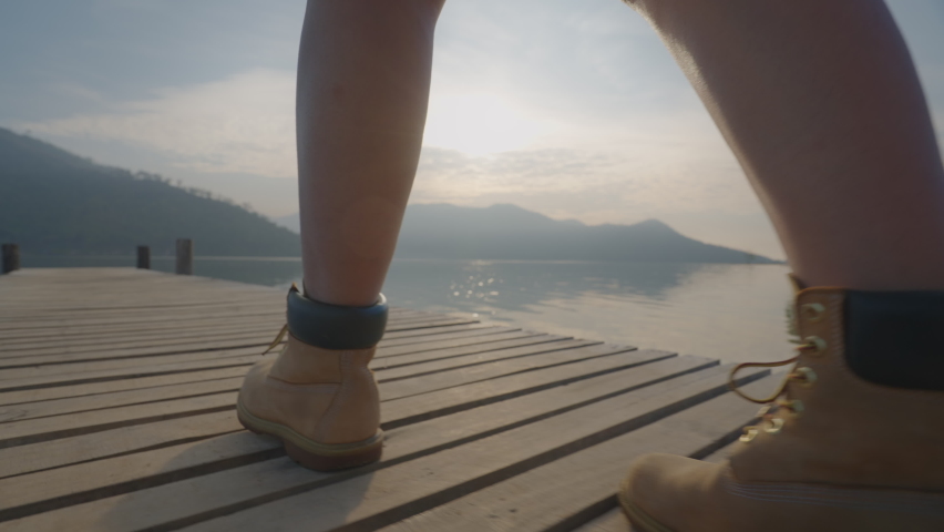 Close-up leg and hiking boot rear view asia serene people solo female enjoy budget trip look outside remotely escape life get away to beauty silence river wild and fog on pier path way rural scene.