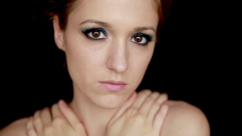 Sad woman in depression. Young woman with blue eyeshadows on black background