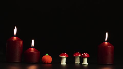 Burning candles, toadstools and pumpkin, Halloween horror story. Isolated image on black background, copy space. Video, footage or background for splash screen, credits, cutouts, intro. UHD 4K.