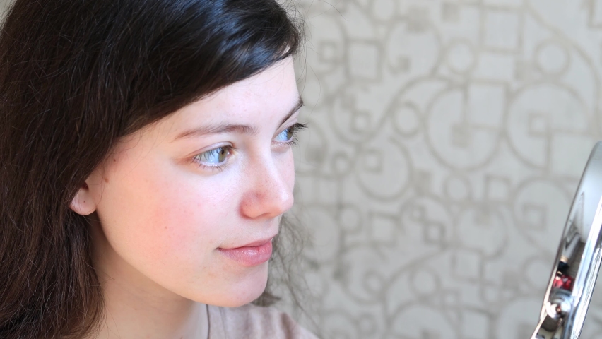 young woman removes contact lenses