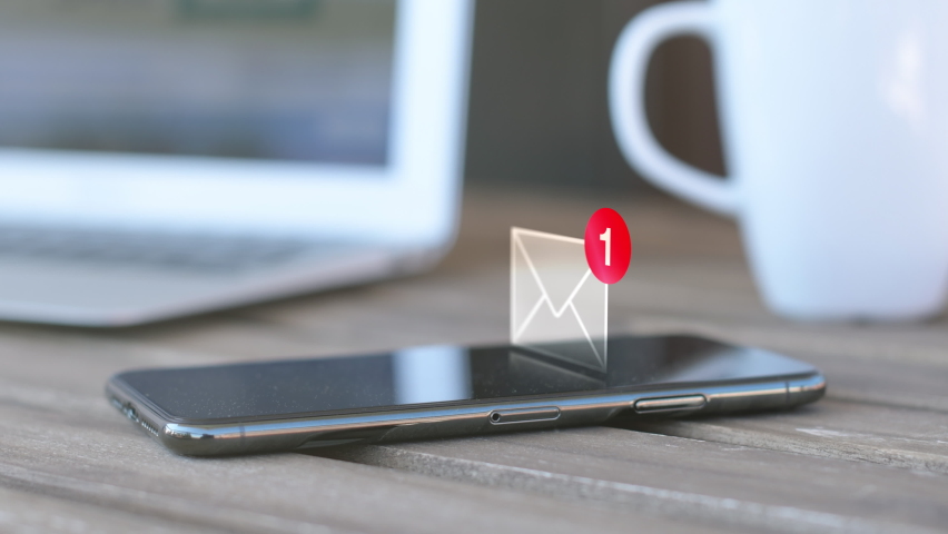 Text message received on mobile smart phone, animated envelope icon with laptop and coffee cup in background Royalty-Free Stock Footage #1086657218