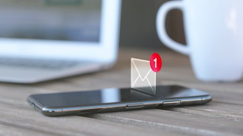 Text message received on mobile smart phone, animated envelope icon with laptop and coffee cup in background