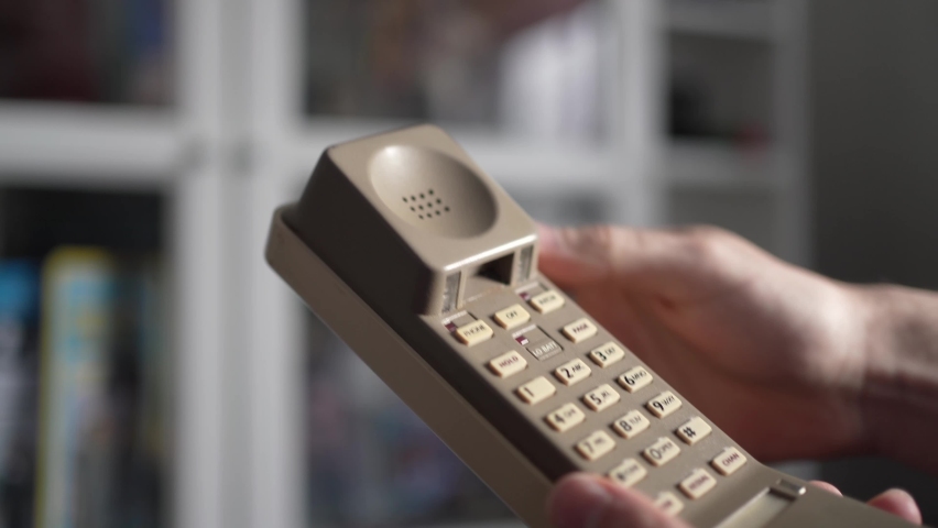 Using a old retro portable telephone from the 90s or 80s to place a call. Close-up of the brick phone being used Royalty-Free Stock Footage #1086661955