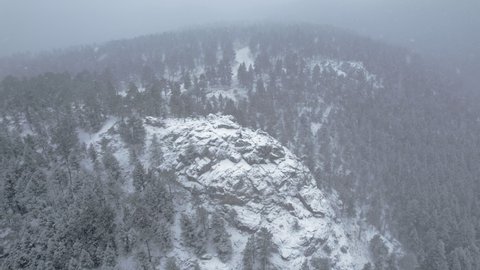 Drone Aerial Footage of Snowcapped Rocky Hill Peak In Flatirons Mountain Boulder Colorado USA.