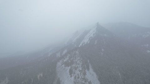 Drone Aerial Footage Flying Towards Snowcapped Flatirons Mountain Near Boulder Colorado USA During Snowstorm Blizzard.