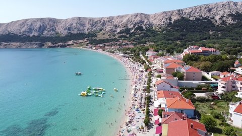 Baška Beach, Krk island, Croatia - Aerial Drone View of Tourists, Boulevard, Sunbeds and Water Playground at a Sunny Summer Day