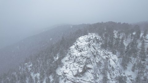 Drone Aerial Footage Flying Around Snowcapped Rocky Hill Peak In Flatirons Mountain Boulder Colorado USA.