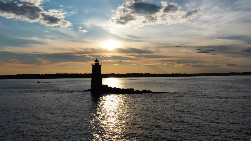 Portsmouth, NH lighthouse Aerial Pass by shadowed sunset sea