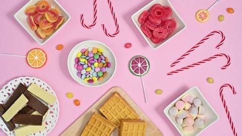 6k sweet candies and lollypops appear on pastel pink theme. Stop motion animation flat lay
