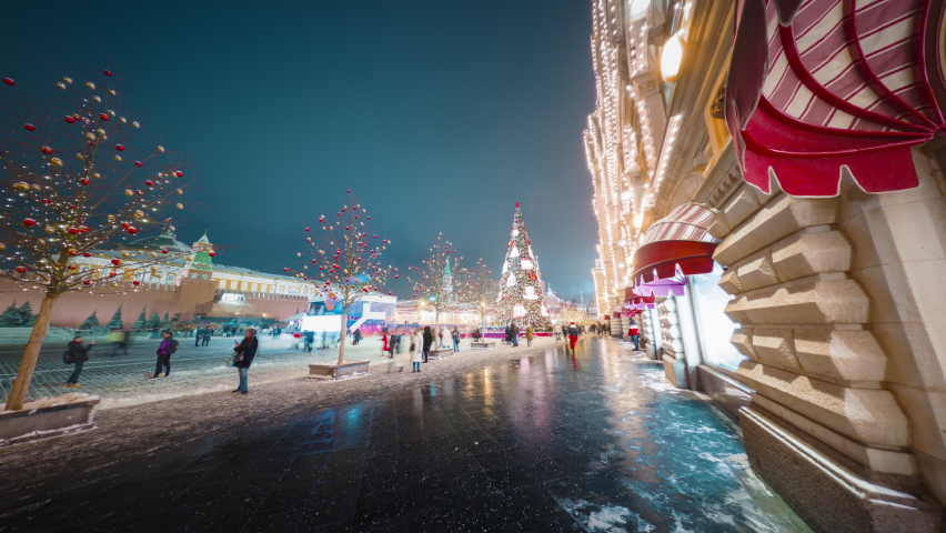 Beautiful New Year decorations on the streets of Moscow with glittering lights of GUM facade, huge Christmas tree on the Red Square and people moving around in motion timelapse.