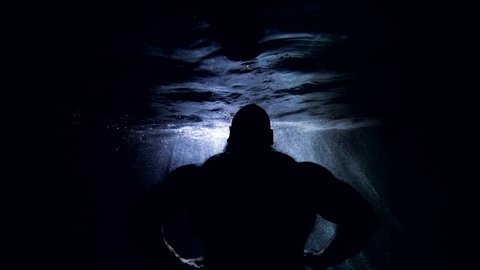 power of Poseidon or Neptune, male figure underwater, man is floating in dark depth