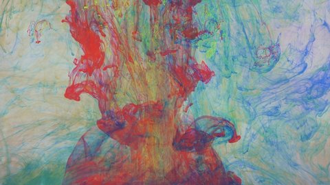 Liquid abstractions, the dissolution of blue, yellow, red and green paint in water.