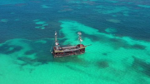 Pirate ship floating in caribbean sea. It is popular excursion for tourists. Dominican Republic. Aerial top view