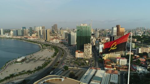 Luanda, Angola - June 06th 2018:4K drone view over the skyline of Luanda downtown with flag of angola,highway and the Luanda bay. 