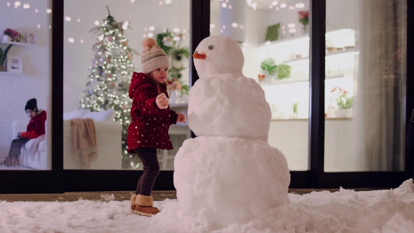kids are having fun, playing with snowman on patio at winter night Royalty-Free Stock Footage #1086682847