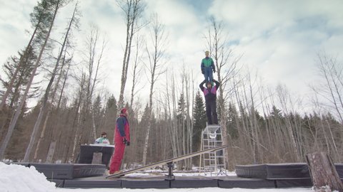 SLOW MOTION - circus performers balancing on shoulders, teeterboarding