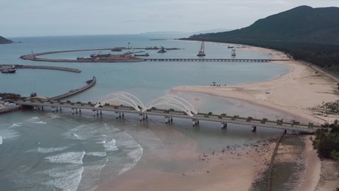 Aerial shot of tropical beach coastline with artificial island land reclamation in backgroud. Sanya, Hainan, China.